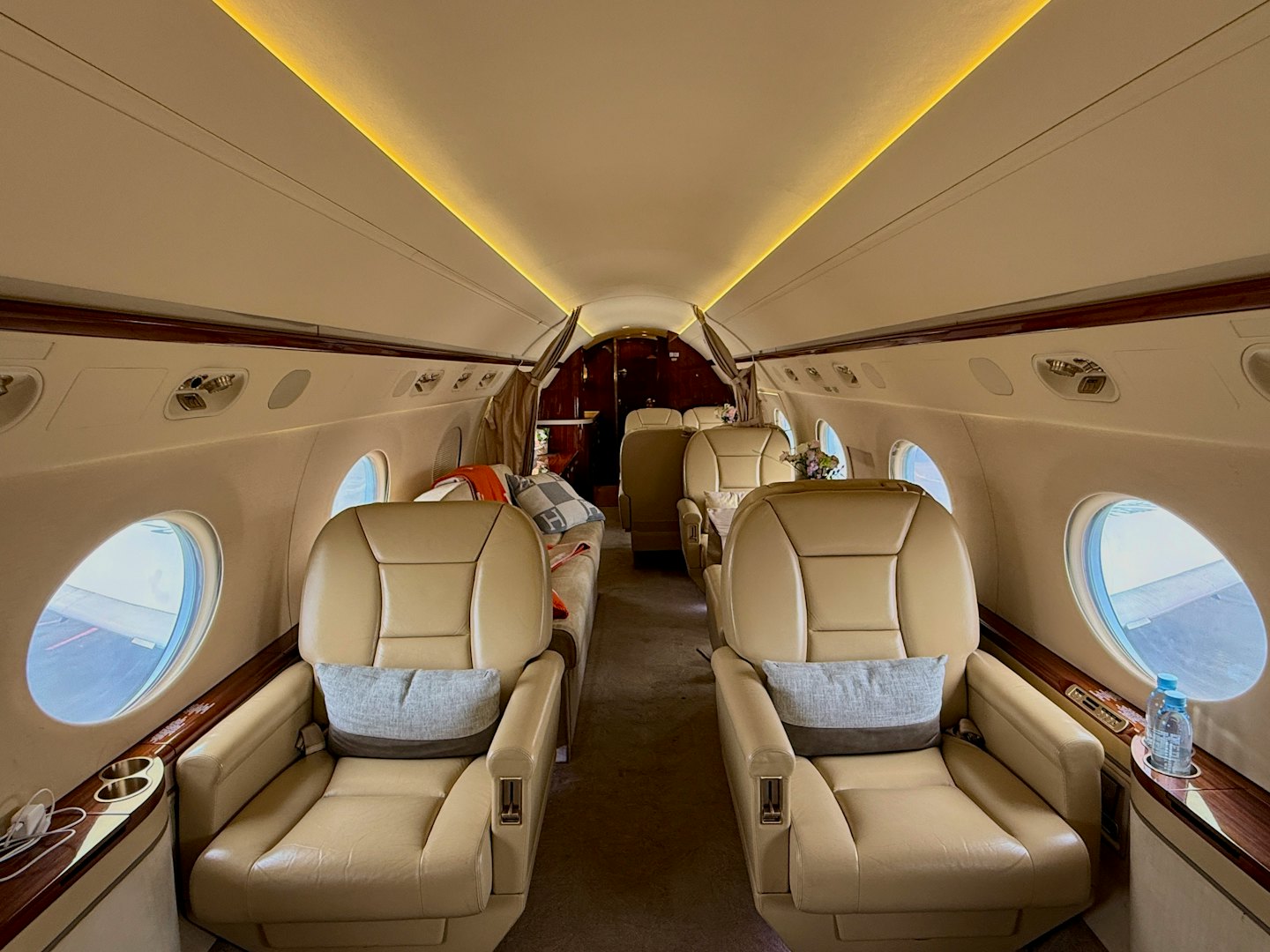 Sièges en cuir beige disposés dans la cabine d'un jet privé.