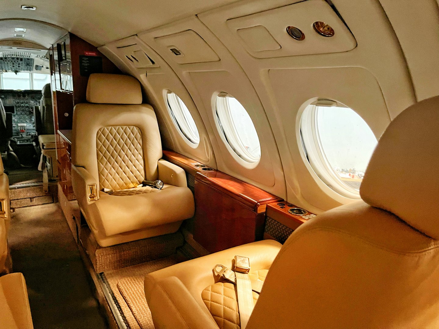 Cabine de jet privé luxueuse avec sièges en cuir moelleux et boiseries.